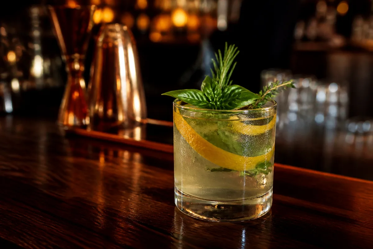 Verre sans alcool garni d&rsquo;herbes fraîches et de zeste d&rsquo;agrume